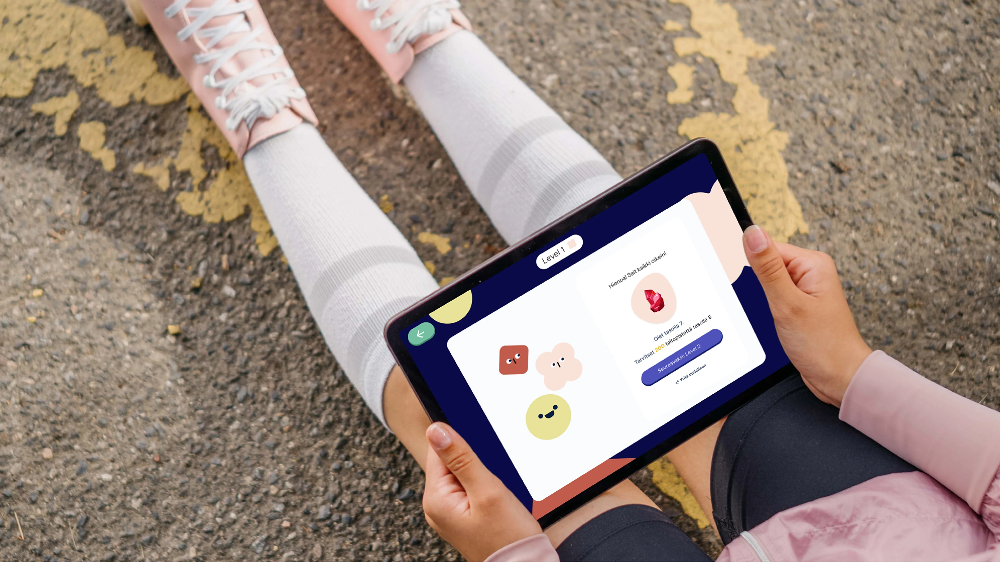 Lapsi istuu asfaltilla tabletin kanssa